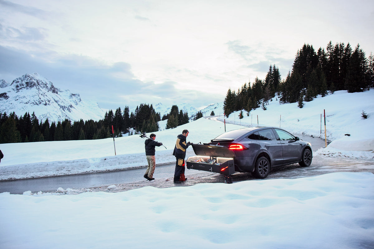 Auto mit einer IXTAbox an der Anhängerkupplung in verschneiter Berglandschaft