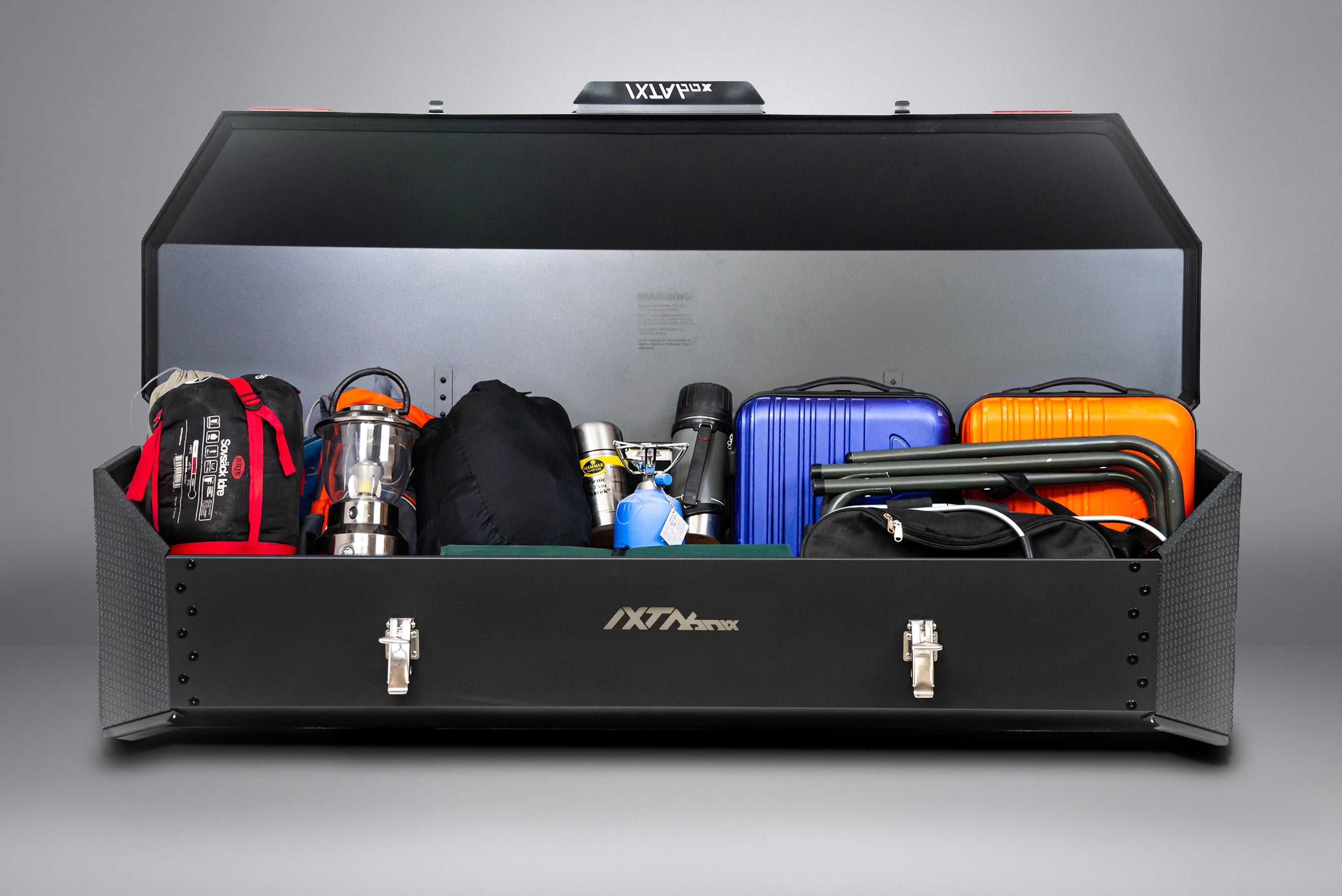 IXTAbox Classic cargo box loaded with camping equipment, showing full storage capacity in real-world use