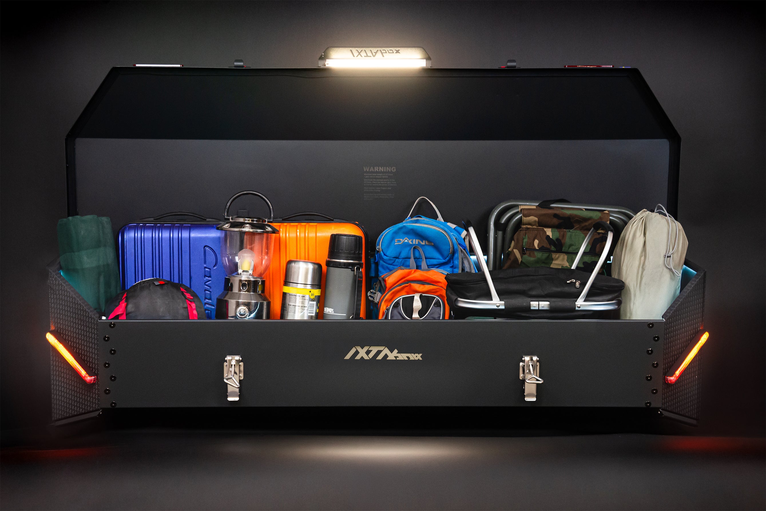 IXTAbox Pro cargo box loaded with sports camping equipment, showing full storage capacity in real-world use
